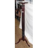 An antique mahogany torchère formed from a tester bedpost, set on tripod base with pad feet