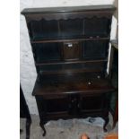 A 36" early 20th Century stained oak two part dresser in the antique style with two shelf open plate