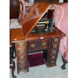 A late 19th Century walnut "drop" cased Singer sewing machine with a lift-top and pop-up action, a