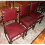 A set of six stained oak framed panel back dining chairs with studded red leather upholstery, set on