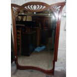 A 3' 11" Art Nouveau mahogany framed decorative wall mirror with shaped and pierced decoration to