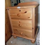 An 18" modern polished pine bedside chest of three drawers, set on turned feet