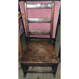 A Georgian oak ladder back rustic rocking chair with solid seat and simple square supports