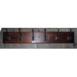 A 33 1/2" wall mounted stained wood coat rack with six hooks