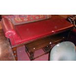 A 6' late Victorian walnut framed examination table with studded red rexine upholstery, set on