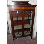 A 30 1/4" Edwardian mahogany display cabinet with stencilled decoration and material lined shelves