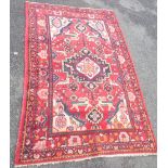 A Persian rug with central medallion and spandrels, rabbits and birds to main on red ground - 6' 10"