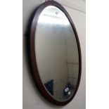 An early 20th Century walnut and strung framed bevelled oval wall mirror