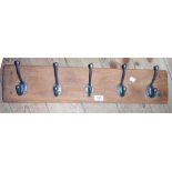 A 27 1/2" rustic oak wall mounted coat rack with five hooks