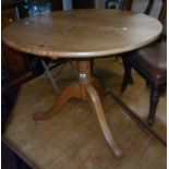 A 33" diameter waxed pine bird cage table, set on turned pillar and tripod base