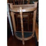 An early 20th Century oak bow front umbrella stand with moulded decoration, turned front supports