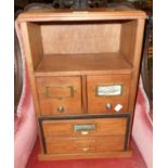 A 13" stained mixed wood table-top filing chest with open shelf and four drawers