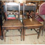 A pair of antique mahogany hall chairs with rustic pierced back rails and solid panel seats, set