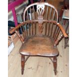 An antique yew Windsor elbow chair with double pierced splat back and moulded solid elm seat, set on