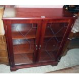 A 33" New Plan mahogany effect book cabinet enclosed by a pair of etched glazed panel doors, set