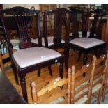 A set of four reproduction stained wood framed dining chairs with pierced splat backs and