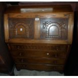 A 30" 20th Century polished oak bureau with part fitted interior and carved panels to fall over four