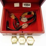 A red leather watch box containing various wristwatches including yellow metal cased Garrard with