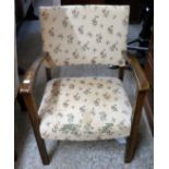 A 1930`s stained beech framed elbow chair with remains of original floral print upholstery