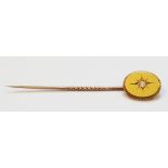 An unmarked yellow metal stick pin with small old cut diamond solitaire set oval panel top