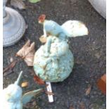 A small painted cast iron garden fairy sat on a flower ball