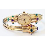 An Indian Titan marked 18k ornate lady's dress wristwatch, set with emerald and ruby cabochons, from