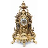 An ornate reproduction cast brass cased salon mantel clock with urn finial, shell motif and all over