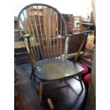 An Ercol dark elm hoop stick back elbow chair frame with moulded solid seat