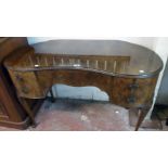 A 3' 11" 20th Century walnut veneered kidney shaped dressing table with blind frieze drawer and four