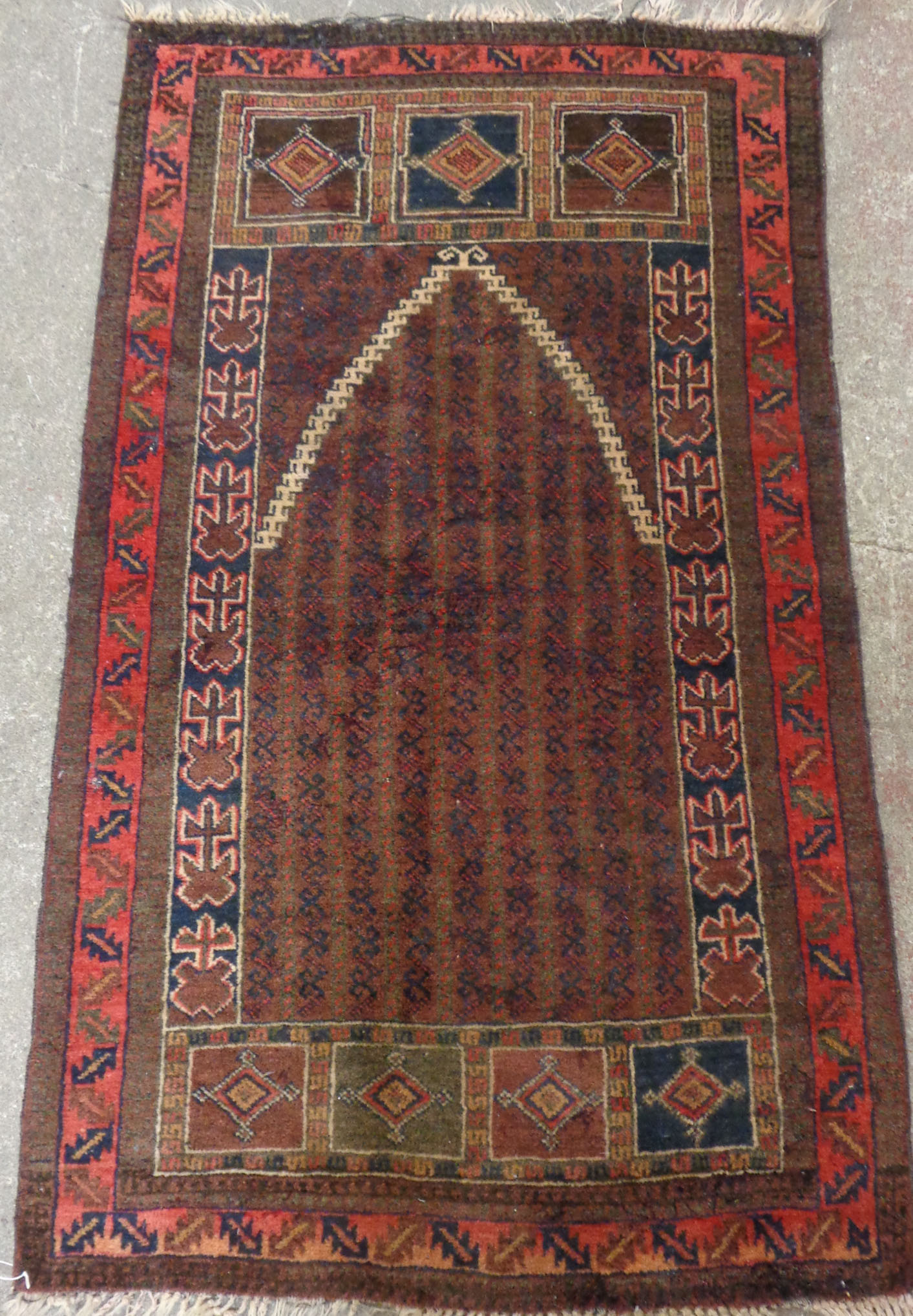 An old Middle Eastern wool prayer rug with mihrab on repeat ground and flanked by geometric panels