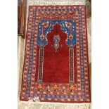 A small prayer rug with mihrab and mosque lamp within repeat floral decoration on red ground - 31" X