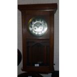 A 20th Century polished oak cased wall clock with visible pendulum and eight day gong striking