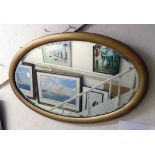 A giltwood framed bevelled oval wall mirror