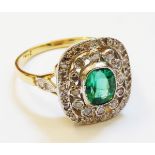A 1920`s style marked 18ct. yellow metal panel ring, set with central oval emerald within a dual