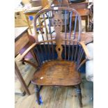 An antique stained mixed wood wheel back elbow chair with moulded and inset solid elm seat, set on