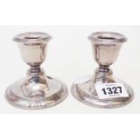 A pair of early 20th Century silver squat candlesticks with loaded circular bases