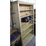 A 4' 3" stripped pine six shelf open bookcase with moulded cornice and plinth base - 6' 9" high