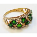 A hallmarked 375 gold pierced ring, set with eight shaped green garnets