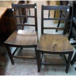 A pair of antique stained wood hall chairs with spindle set backs and solid curved seat panels,