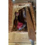 A wicker basket containing vintage sports equipment including golf balls, cricket bat, rugby ball,