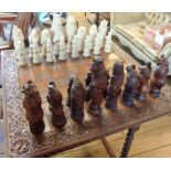 A large chess set and board with lion, bear, monkey and horse pieces