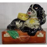 A 1957 Goebel figure of Butch the spaniel lying on a suitcase by Albert Staehle