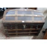 A late Victorian wood and metal bound dome top travelling trunk with canvas weather coating,