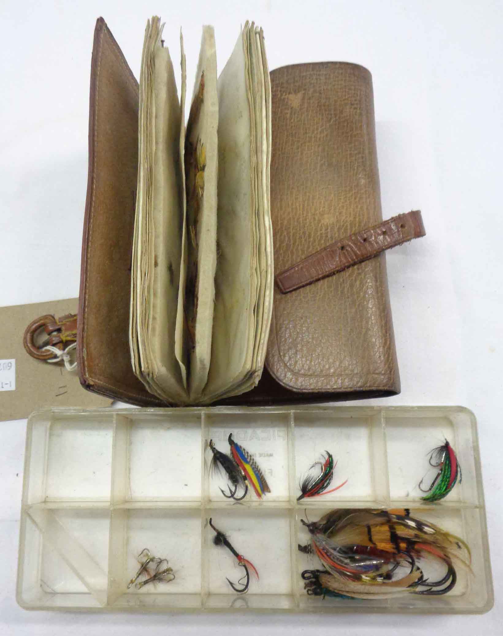 A vintage leather wallet wrap containing a collection of salmon and sea trout flies - sold with a