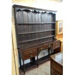 A 7' late Georgian stained oak two part dresser with moulded cornice and shaped frieze to the