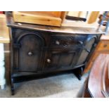 A 4' 1930`s Ercol dark stained elm sideboard, the canted front with central drawer and cupboard,