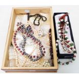 A wooden box containing various modern coloured baroque and other pearl necklaces, also loose