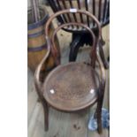 A late 19th Century child's continental bentwood elbow chair with machine pressed circular seat