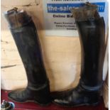 A pair of old black leather riding boots with trees