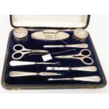 A cased ten piece silver mounted manicure set including nail buff, two faceted cut glass jars and
